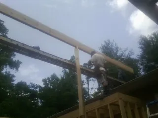 Carpenter setting a ridge beam over a new addition frame — Ice Dam Removal by Roofing Brothers in Gilsum