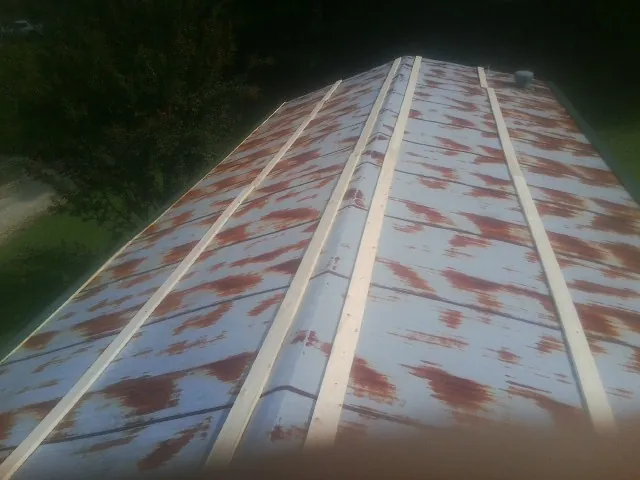 Rusted metal roof panels with new wood purlins before replacement — Storm Damage Roof Repair in Gilsum by Roofing Brothers