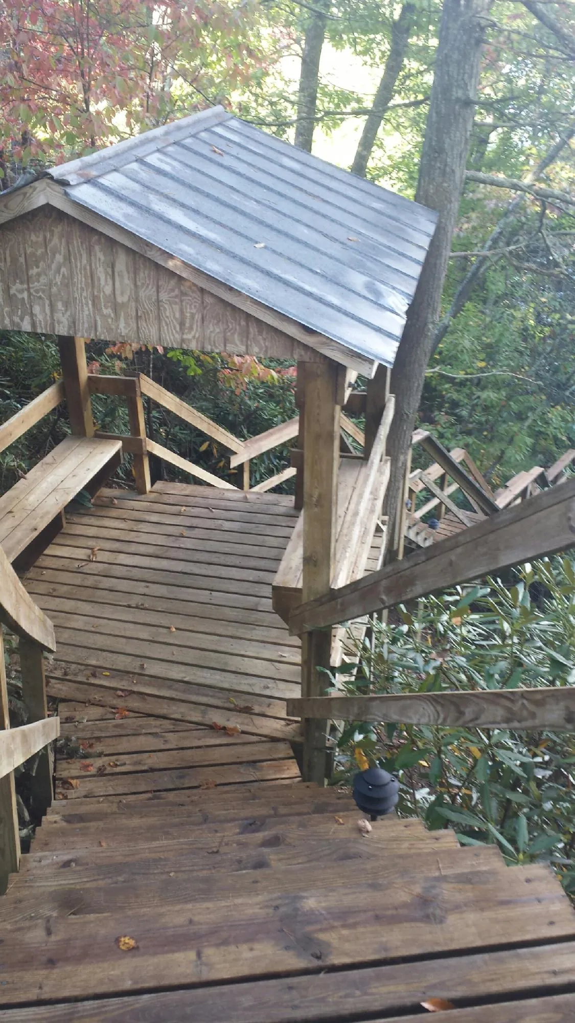 Metal roofed shelter over wooden steps on a wooded walkway — Skylight Repair & Installation work by our crew in Gilsum